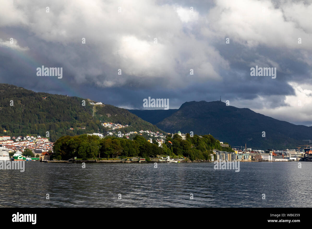 Blick auf Eingang in den Hafen von Bergen, Norwegen. Nordnes und der kommerziellen Hafen. Mount Floyen und Ulriken. Blick von der Insel Askoy Stockfoto