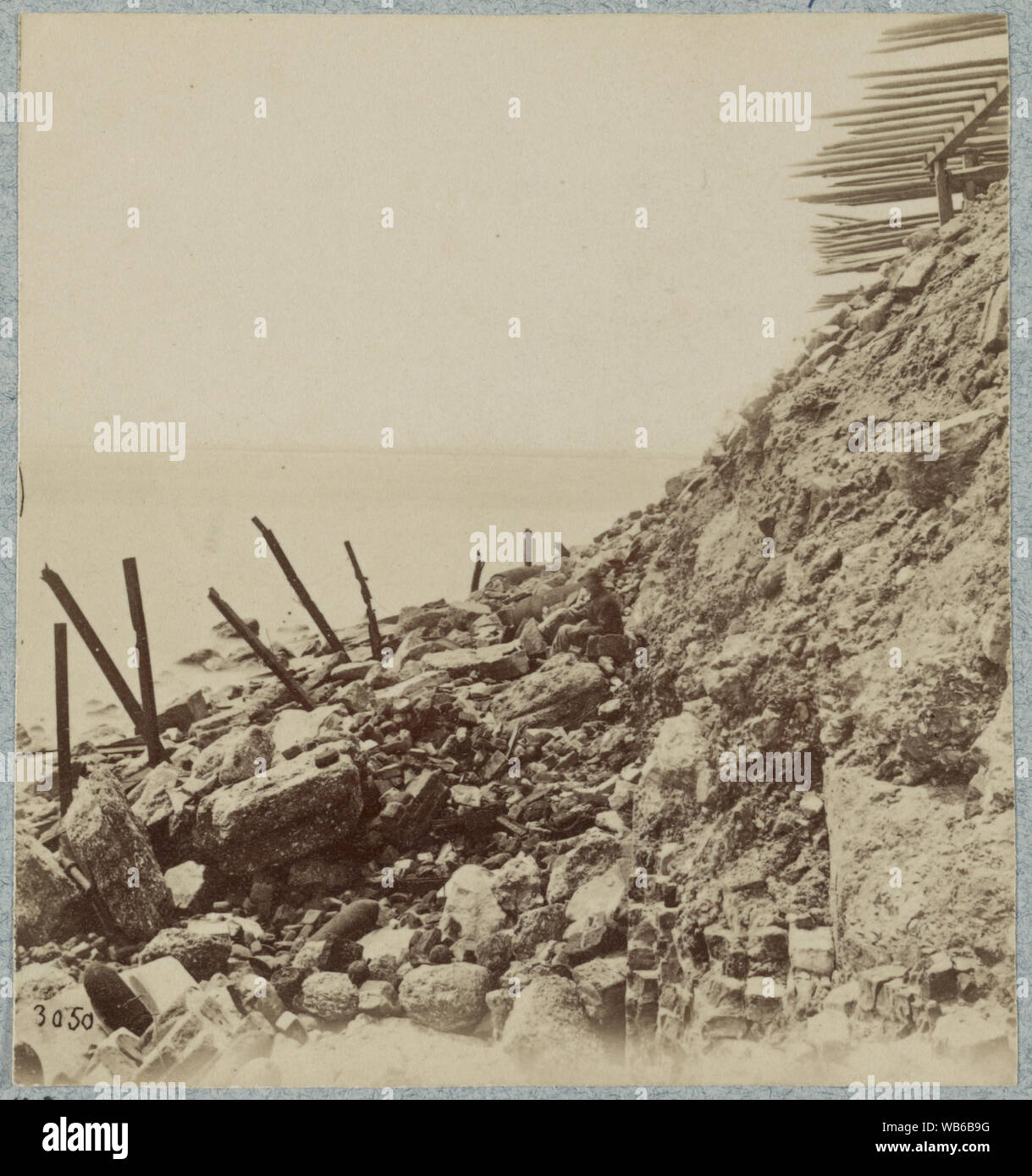 Außenansicht, April, 1865 Abstract: Foto zeigt ein Mann sitzt auf Felsen inmitten der Trümmer des äußeren Wand von Fort Sumter, die ein Ergebnis der Bombardierung vom 17. August bis 23. September 1863. Auch Chevaux-de-frise zum Schutz vor Übergriffen. Stockfoto