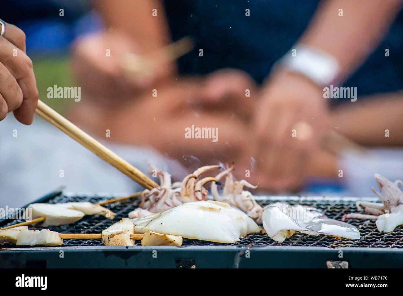 Frische Kalmare und Pilze auf dem Grill Gitter Stahl. Stockfoto