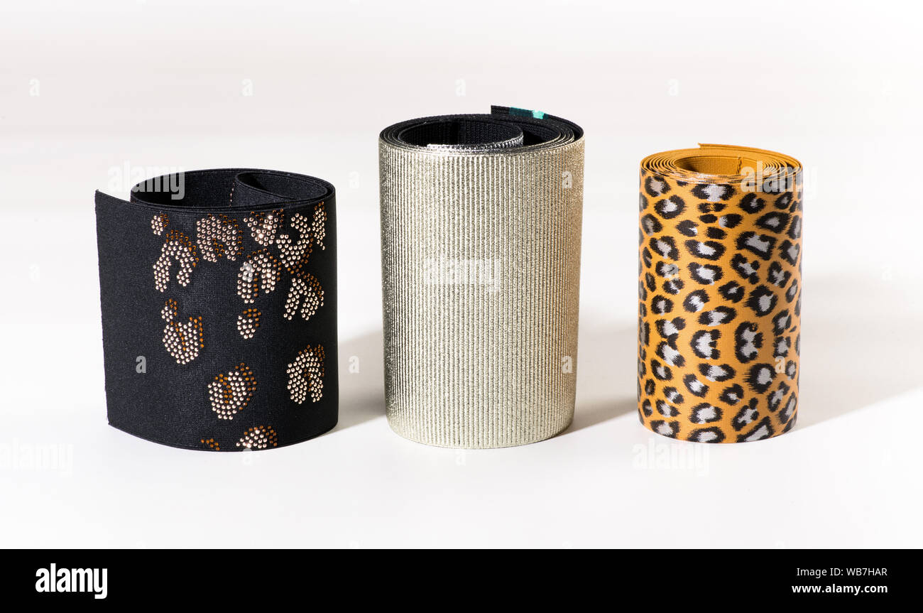 Drei breite Rollen von dekorativen elastische Bänder oder Streifen mit Leopardenmuster, gesäumt von Textur und Muster auf Schwarz stehend auf Weiß Stockfoto