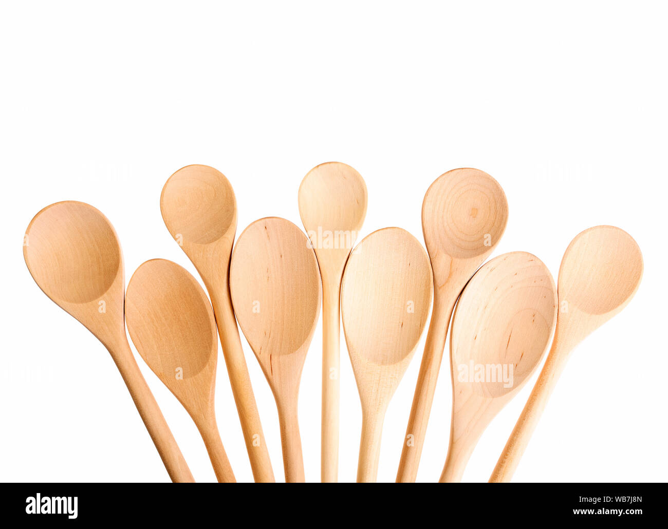 Leeren Löffel in verschiedenen Größen isoliert. Viele Holzlöffel auf weißem Hintergrund für Text. Stockfoto