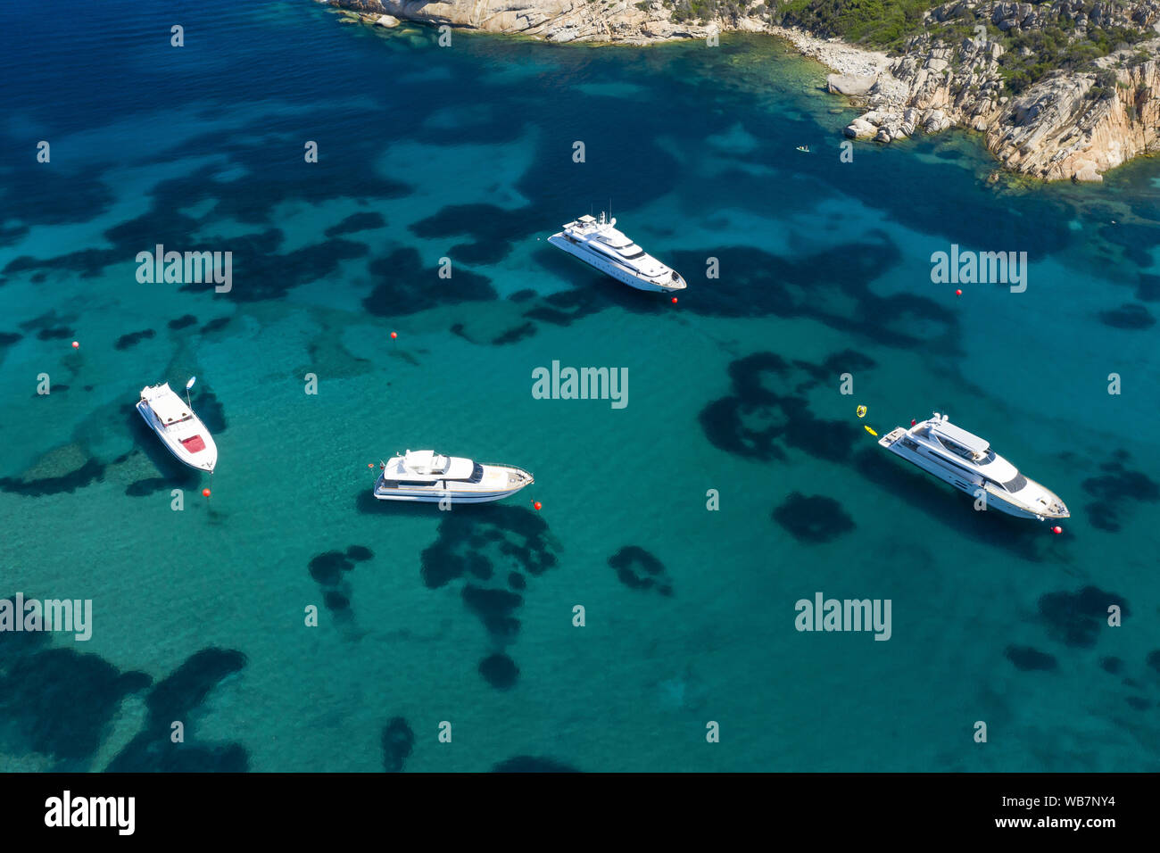 Ansicht von oben, beeindruckende Luftaufnahme von Luxus Yachten und Boote schwimmend auf einem smaragdgrünen Bucht von Wasser in Sardinien. Maddalena Archipel, Sardinien Stockfoto