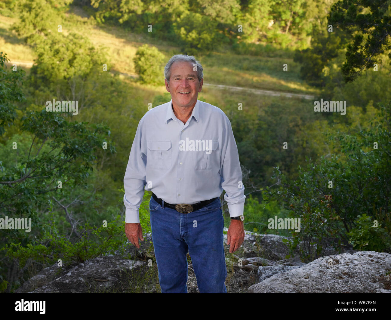 Der frühere US-Präsident George W. Bush zu einem Canyon auf seinem 1.600-acre Ranch, Website der Texas White House während ihrer Besuche dort während Bushs Präsidentschaft, in der Nähe von Crawford in McLennon County, Texas übersehen. Herr Bush genießt Wandern und Reiten sein Mountainbike auf einer felsigen Trail in der Nähe von dieser Website Stockfoto