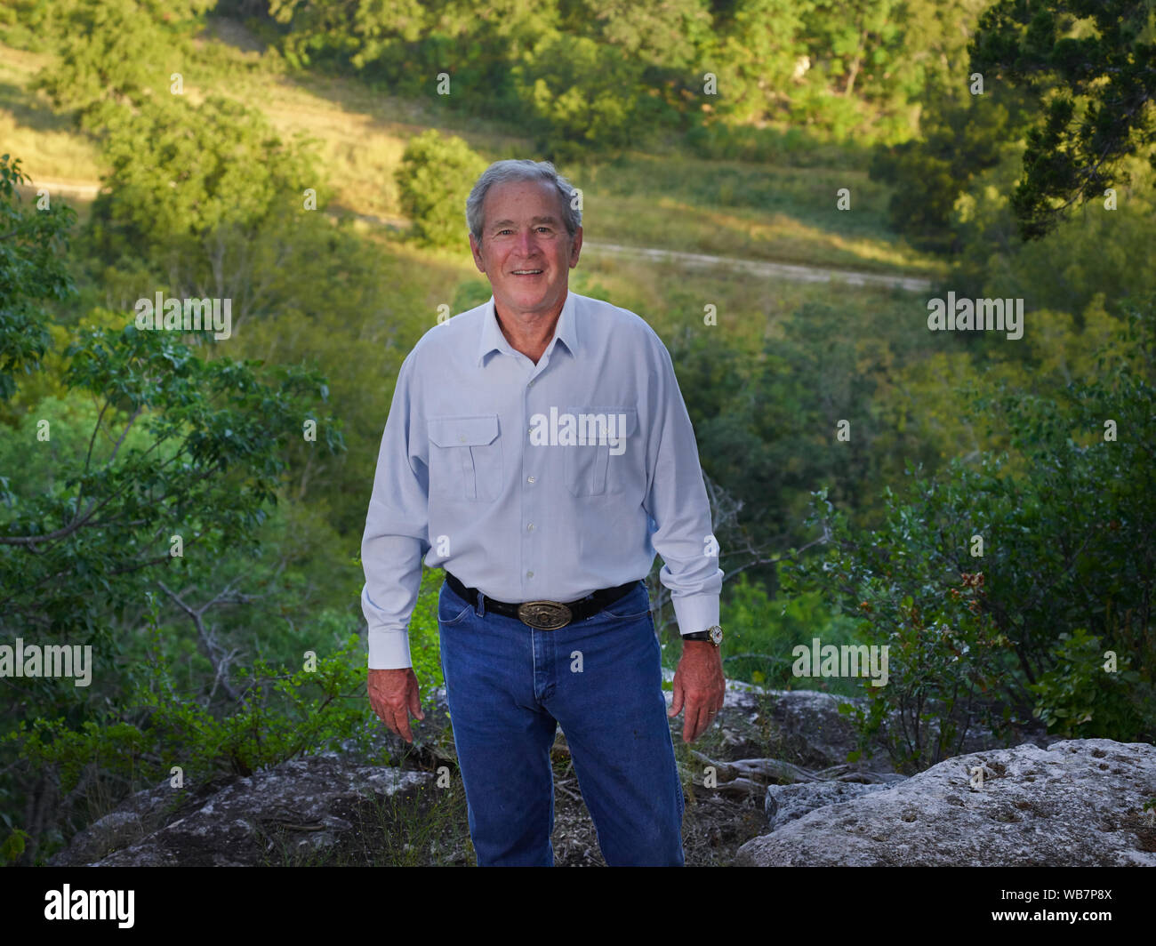 Der frühere US-Präsident George W. Bush zu einem Canyon auf seinem 1.600-acre Ranch, Website der Texas White House während ihrer Besuche dort während Bushs Präsidentschaft, in der Nähe von Crawford in McLennon County, Texas Herr Bush übersehen genießt Wandern und Reiten sein Mountainbike auf einer felsigen Trail in der Nähe von dieser Website Stockfoto