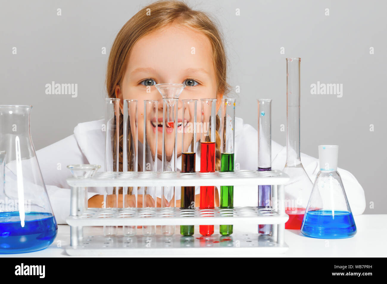 Kleines Mädchen student schaut Reagenzgläser. Ein Kind ist die Durchführung einer chemischen Experiment. Stockfoto