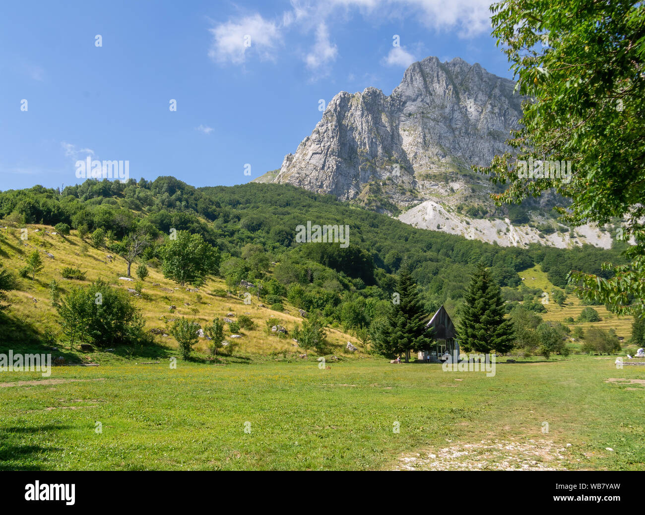 CAMPOCATINO, GARDFAGNANA, ITALIEN - August 9,2019: Blick auf campocatino Landschaft mit Berg Roccandagia, Apuanischen Alpen, hinter und in der kleinen Kapelle auf der Vorderseite. Stockfoto