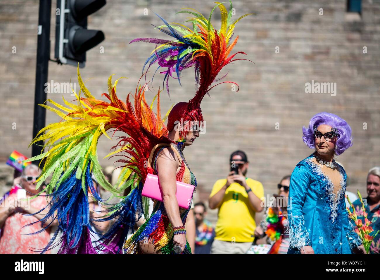 Eine Person in extravaganten Kleid erscheint Downbeat während der Stolz Cymru 2019 Parade in Cardiff. Stockfoto