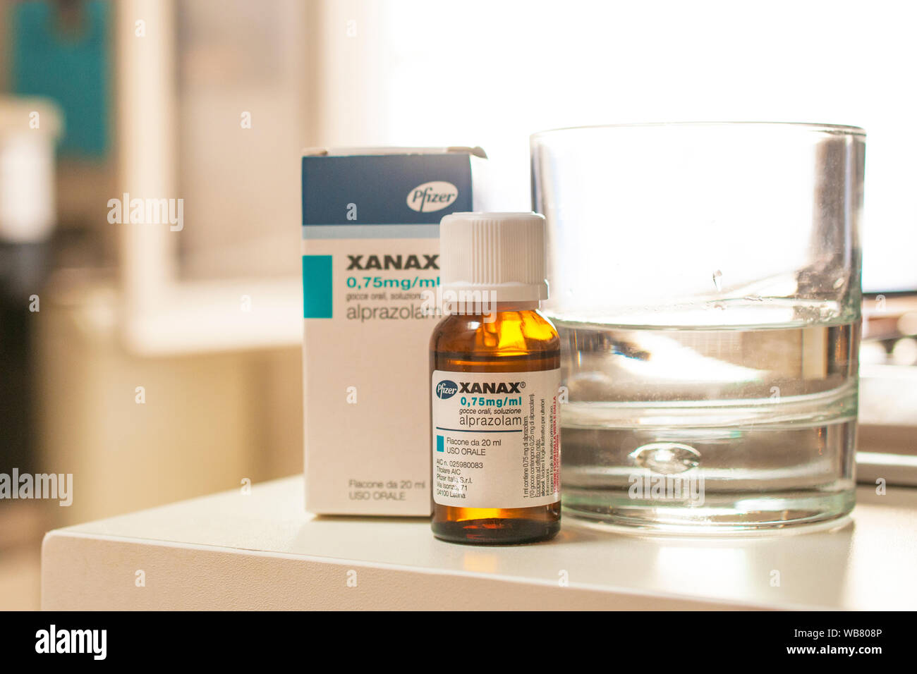 Flasche Xanax Tropfen mit der Box und ein Glas Wasser. Es wird in der Regel bei kurzfristigen Management von Angststörungen eingesetzt. Stockfoto