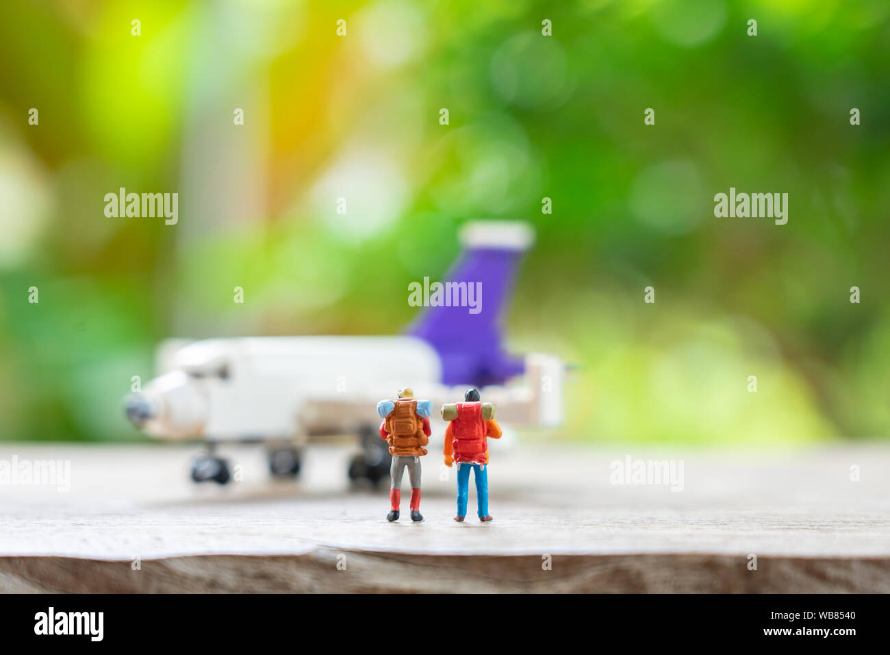 Miniatur 2 Leute stehen Reiseplaner mit dem Flugzeug Modell als Hintergrund Travel Concept mit kopieren. Stockfoto