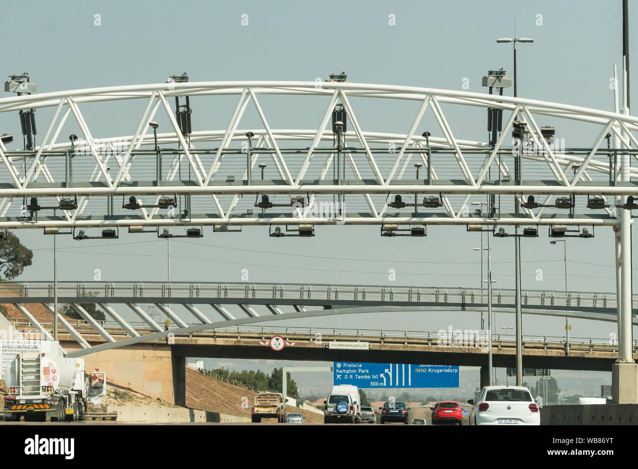 Autos und Fahrzeuge Geschwindigkeit entlang der Autobahn N1 Toll Road außerhalb von Johannesburg, Gauteng, Südafrika unter eine obenliegende Gantry sammeln e Maut Stockfoto