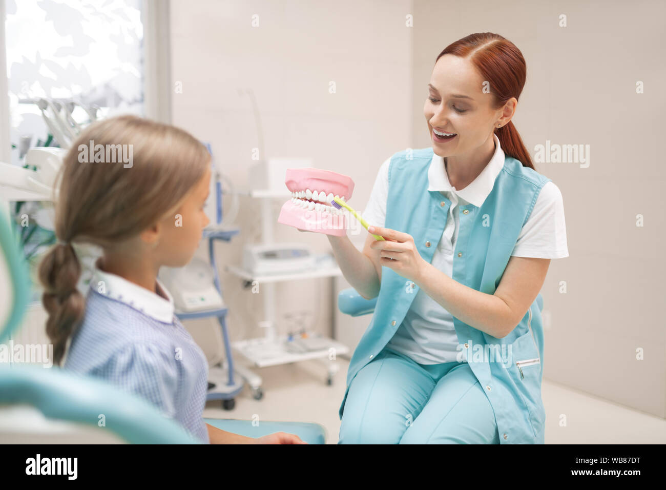 Mädchen aufmerksam zuhören zu Zahnarzt Lehre ihre Zähne richtig zu putzen Stockfoto