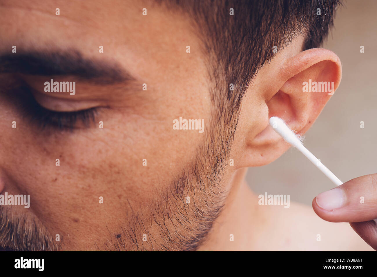 Mann über seine Ohren zu reinigen mit Q-Tip, Wattestäbchen. Hygiene  essentials Konzept. Entfernen von Wachs von Ohr Stockfotografie - Alamy
