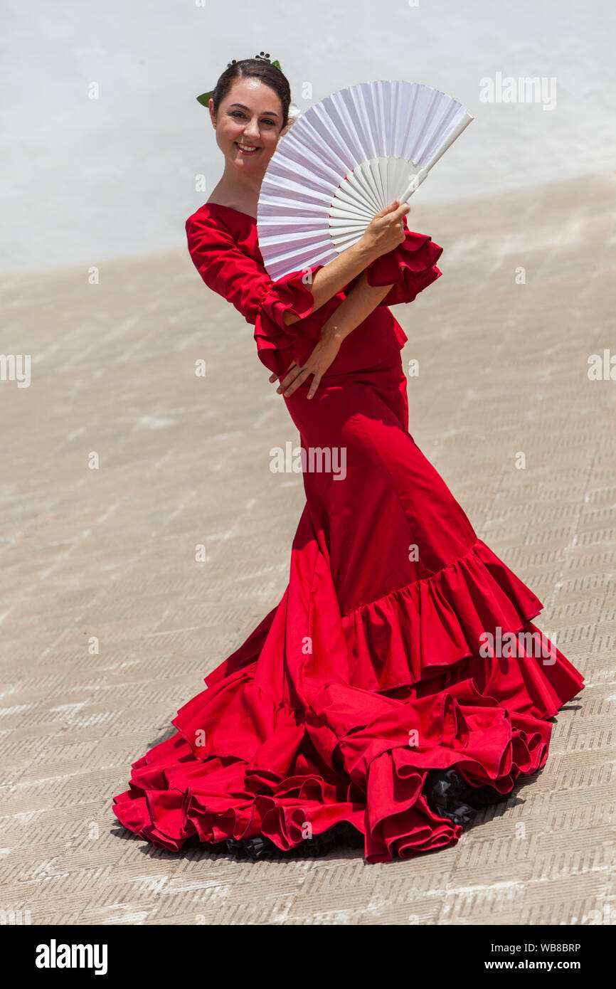 Spanisch weiblich Frau Flamenco Tänzerin Durchführung außerhalb trägt ein  rotes Kleid mit einem weissen Fan posiert Stockfotografie - Alamy