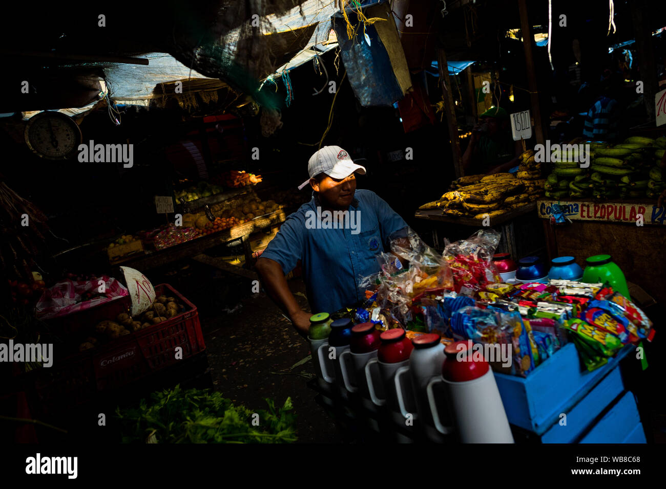 Eine Kolumbianische street Hersteller schiebt einen Einkaufswagen, mit Thermoskannen mit Kaffee und Süßigkeiten geladen, auf dem Markt der Bazurto in Cartagena, Kolumbien. Stockfoto