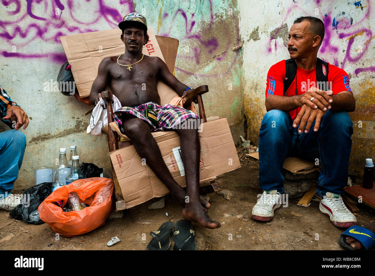 Ein Afro Mann verkauft Schnaps aus großen Flaschen im Markt der Bazurto in Cartagena, Kolumbien. Stockfoto