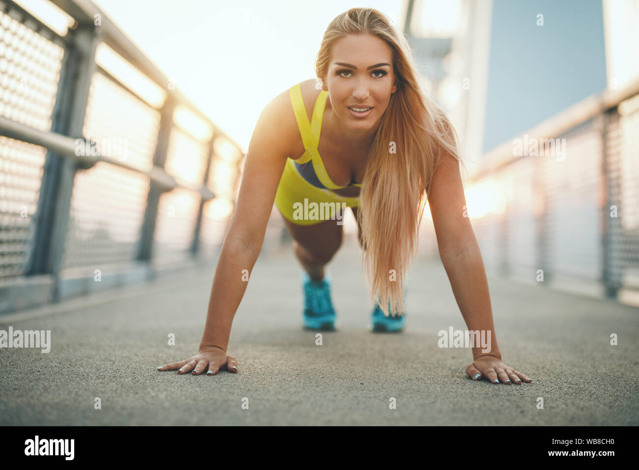 Young Sport Frau tun, Push-up-Übung auf der Brücke während outdoor Cross Training durch den Fluss fokussiert. Stockfoto