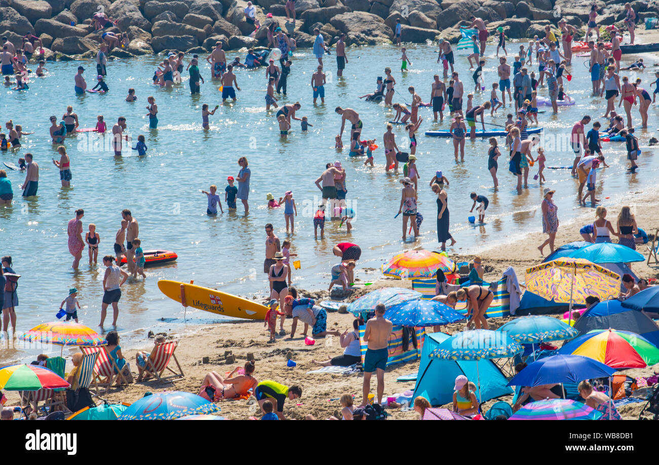 Lyme Regis, Dorset, Großbritannien. 25 Aug, 2019. UK Wetter: unglaublich warmen Sonnenschein und swelterig Wärme, wenn die Temperaturen weiter ansteigen auf Feiertag Sonntag. Massen von Urlaubern und Sonnenanbetern Pack der Strand im Badeort von Lyme Regis. Credit: Celia McMahon/Alamy leben Nachrichten Stockfoto