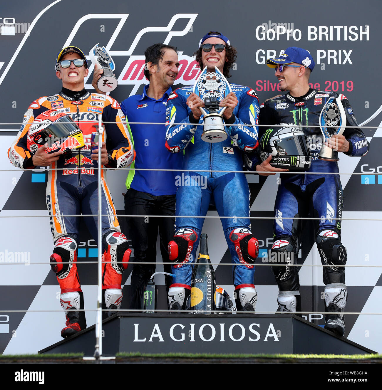 Suzuki's Alex Rins feiert den Sieg auf dem Podium mit Marc Marquez und Maverick Vinales während der GoPro MotoGP Grand Prix von Großbritannien in Silverstone, Towcester. Stockfoto