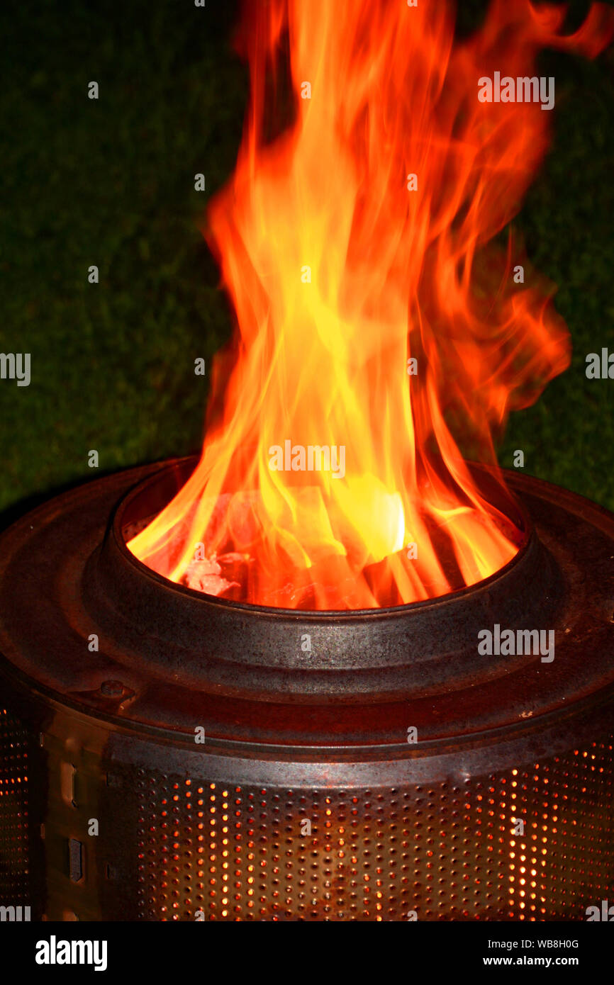 Brennende hausgemachten Grill aus einem Fass eines alten Waschmaschine mit  lodernden Flammen in der Nacht, Kamin aus Trommel der Waschmaschine  Stockfotografie - Alamy