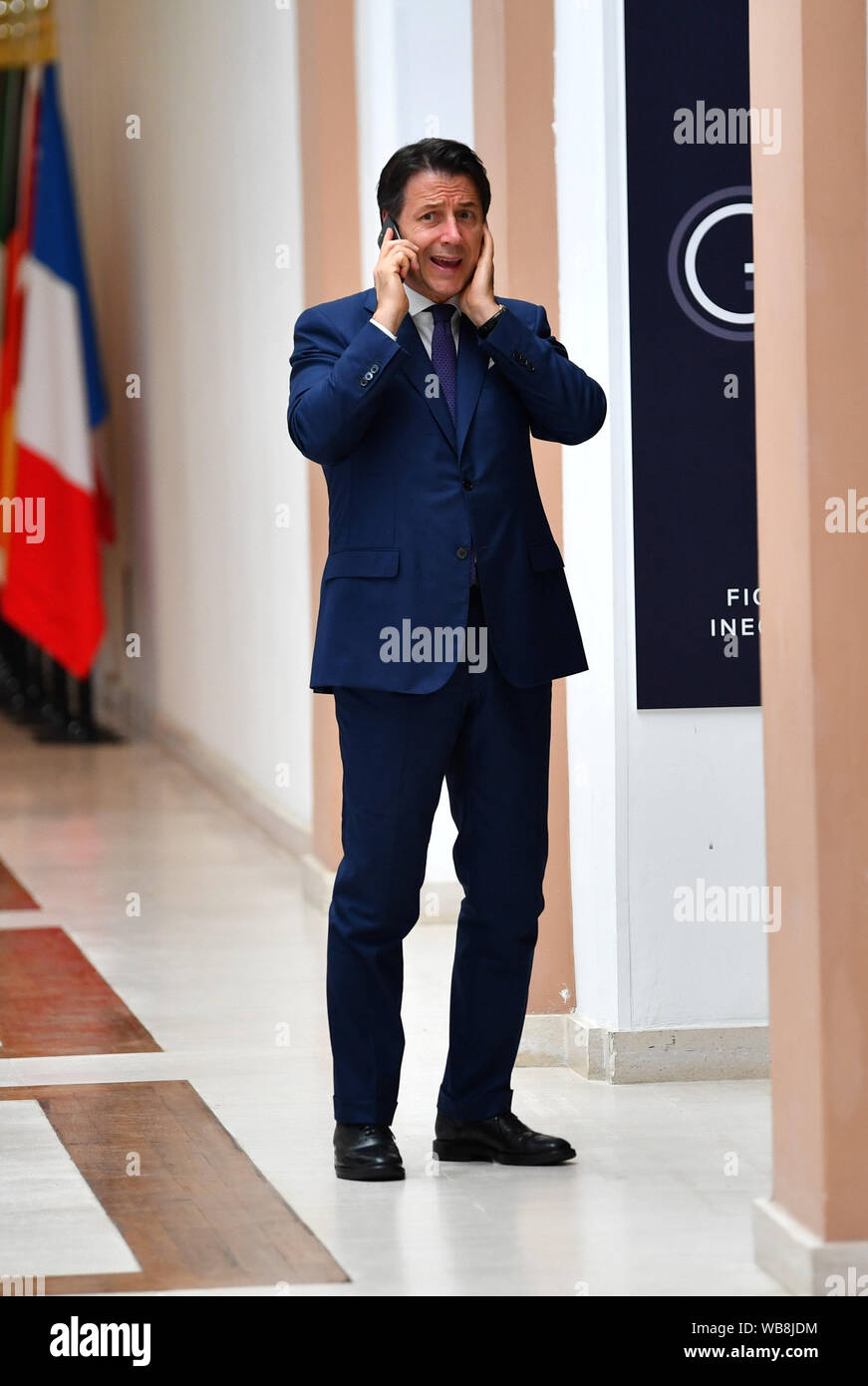 Italiens amtierender Premierminister Giuseppe Conte spricht am Telefon vor der Teilnahme an einem G7 und Afrika Partnerschaft Sitzung während der G7-Gipfel in Biarritz, Frankreich. Stockfoto