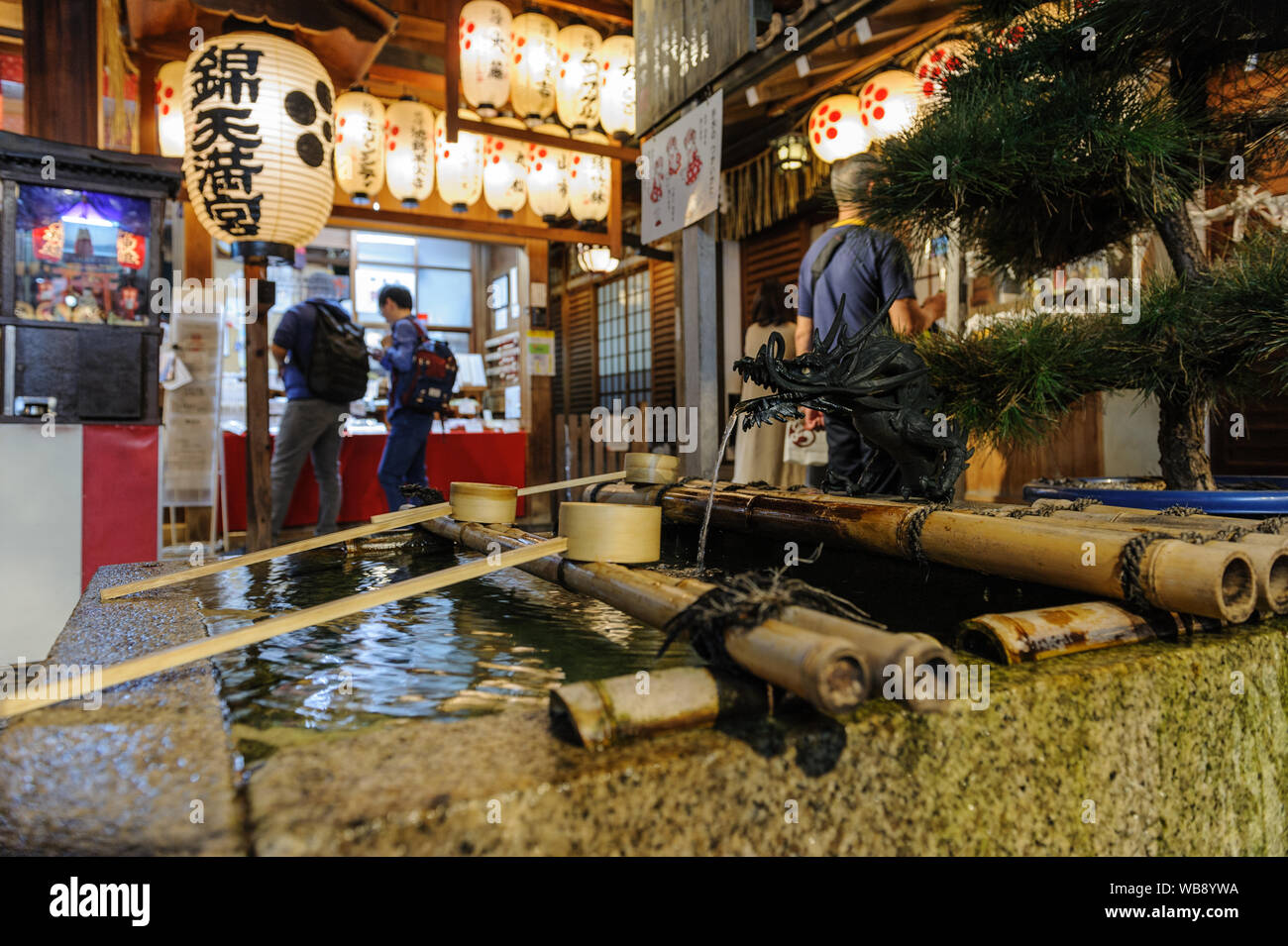 Tradtional shintoistic Wasser Bassin aus Gründen der spirituellen Reinigung in Nishiki Schrein im Herzen von Kyoto erfasst bei Nacht, Japan, November 2018 Stockfoto