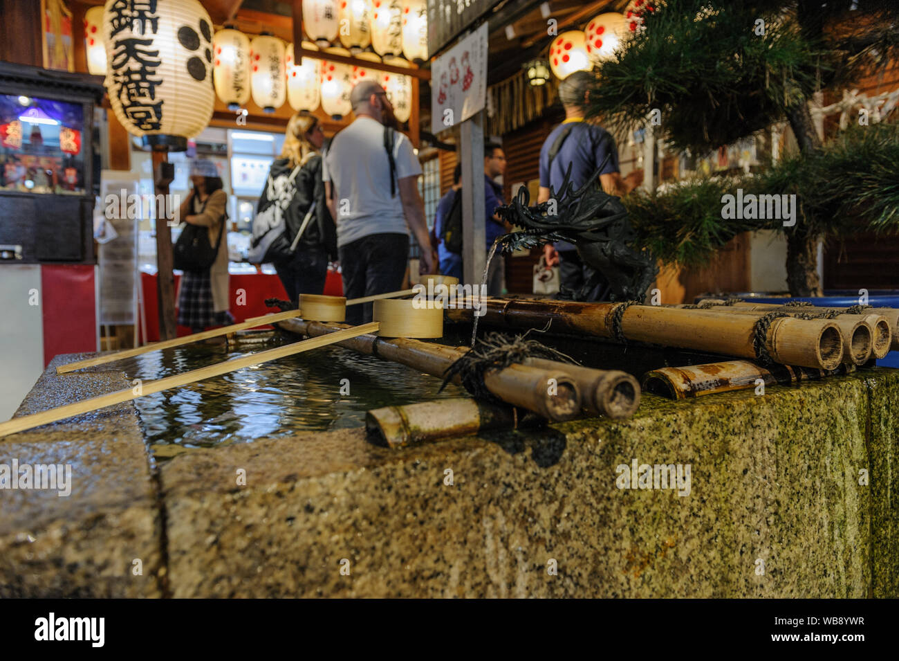 Tradtional shintoistic Wasser Bassin aus Gründen der spirituellen Reinigung in Nishiki Schrein im Herzen von Kyoto erfasst bei Nacht, Japan, November 2018 Stockfoto