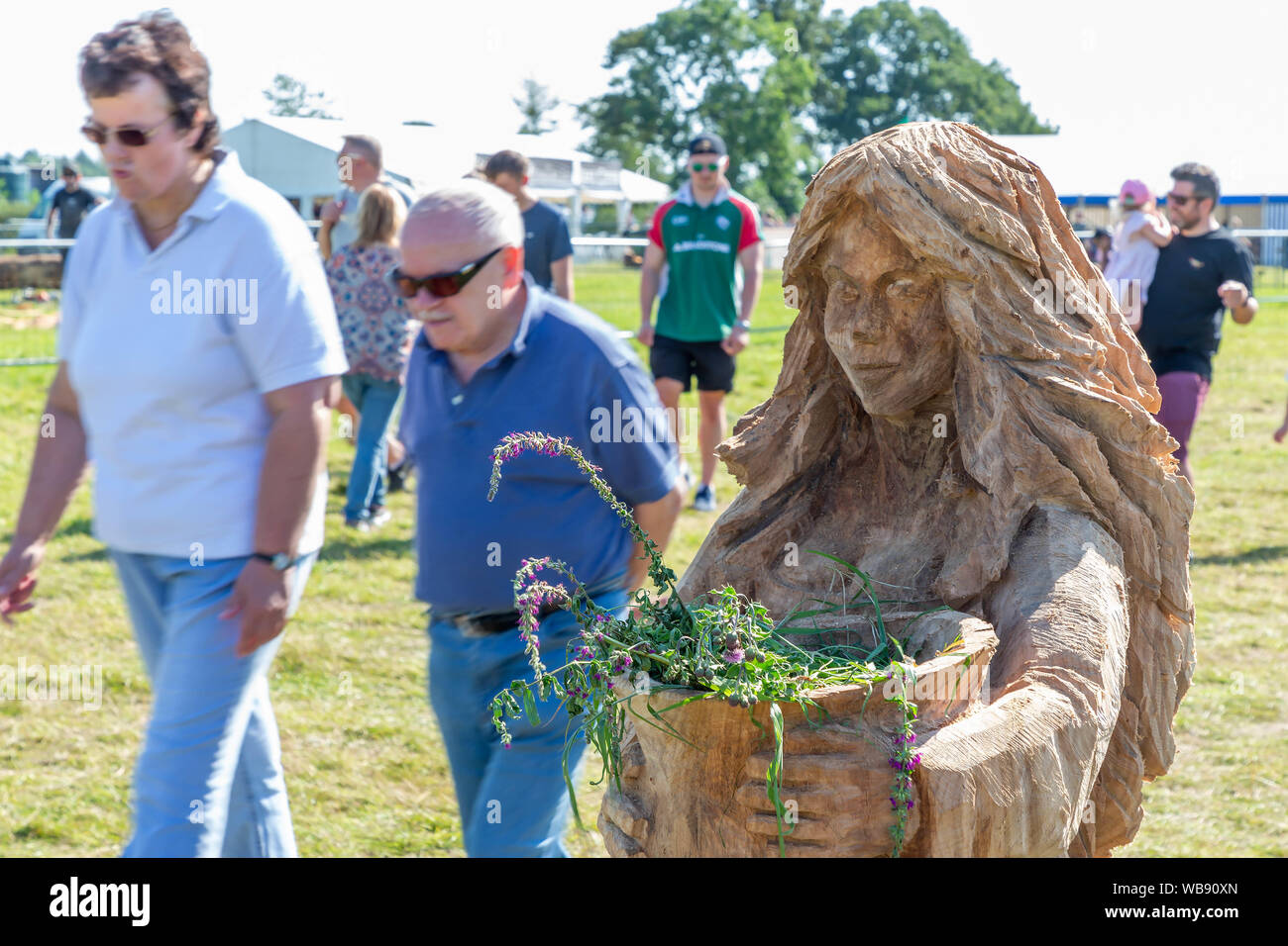 Tabley, Cheshire, UK. 25 Aug, 2019. Die 15 englischen Öffnen Kettensäge Wettbewerb im Cheshire County Showground, England - Besucher vorbei an ein Beispiel von Chainsaw Carving mit toten Blumen Kredit: John Hopkins/Alamy leben Nachrichten Stockfoto