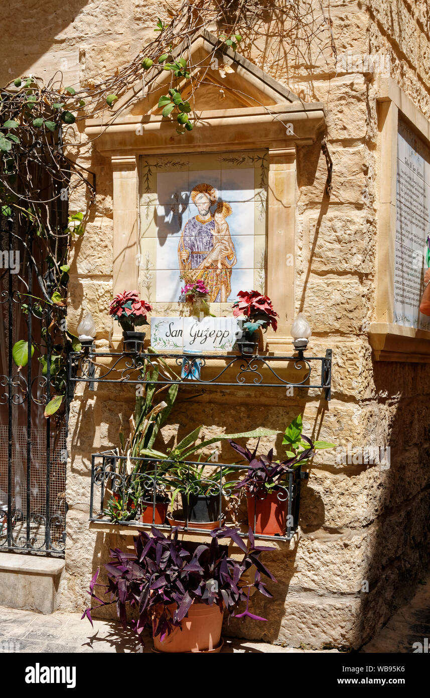 Outdoor Schrein, St. Joseph mit Jesuskind, San Guzepp, keramische Fliese Wanddekoration, religiöse, katholische, Statue, Blumen, Topfpflanzen, Bügeleisen st Stockfoto