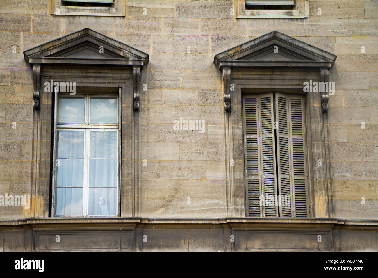In der Nähe der traditionellen Windows mit Arkaden und Fensterläden auf der Fassade eines Gebäudes im historischen Zentrum von Paris. Stockfoto