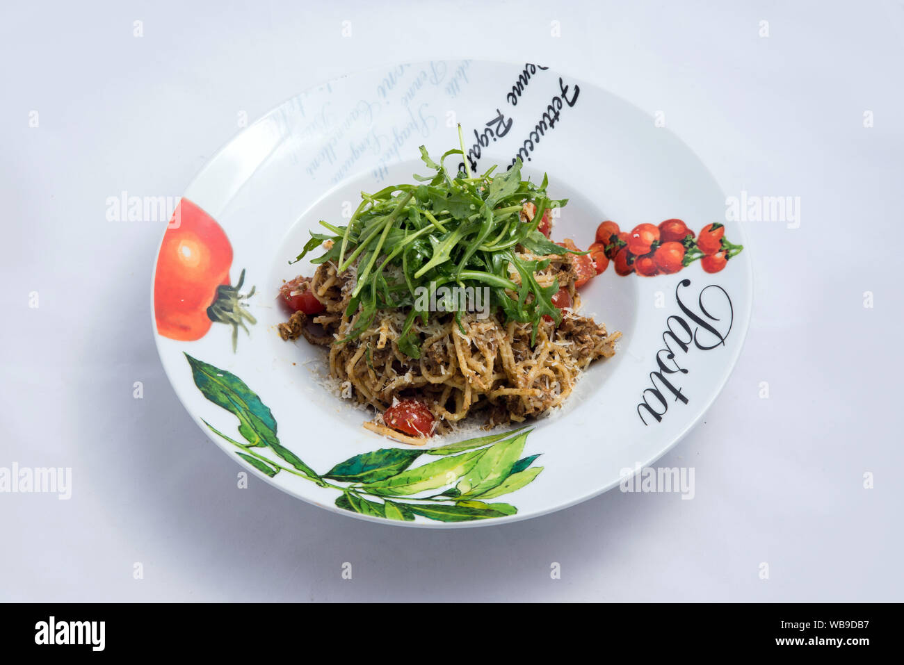 Einen niedrigen Kontrast seitliche hero Schuß eines Thunfisch Thunfisch pasta/Tapenade mit Oliven, Tomaten und Salat, auf einen minimalen weißen Hintergrund mit einem Winkel von 30 Grad fr Stockfoto