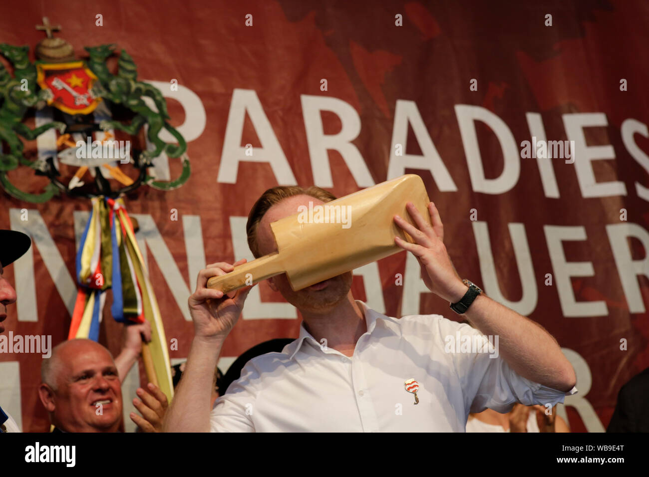 Worms, Deutschland. 24. August 2019. Die lokale Mitglied des Deutschen Bundestages für die CDU (Christlich Demokratische Union) Jan Metzler Getränke Weine aus den traditionellen Kelle Handnirsch (Holz) bei der Eröffnung des Backfischfest 2019. Der größte Wein- und Volksfest am Rhein, das backfischfest in Worms begann mit der traditionellen Übergabe der Macht aus dem Oberbürgermeister, dem Bürgermeister von der Fischer, Lea. Die Zeremonie wurde von Tänzen und Musik umrahmt. Stockfoto