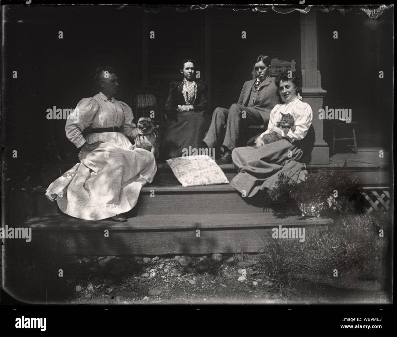 Amerikanische Familie mit Haustieren auf der Veranda, Anfang 1900. Von den ursprünglichen 3 x 4 Zoll Glasplatte Negative scannen. Stockfoto
