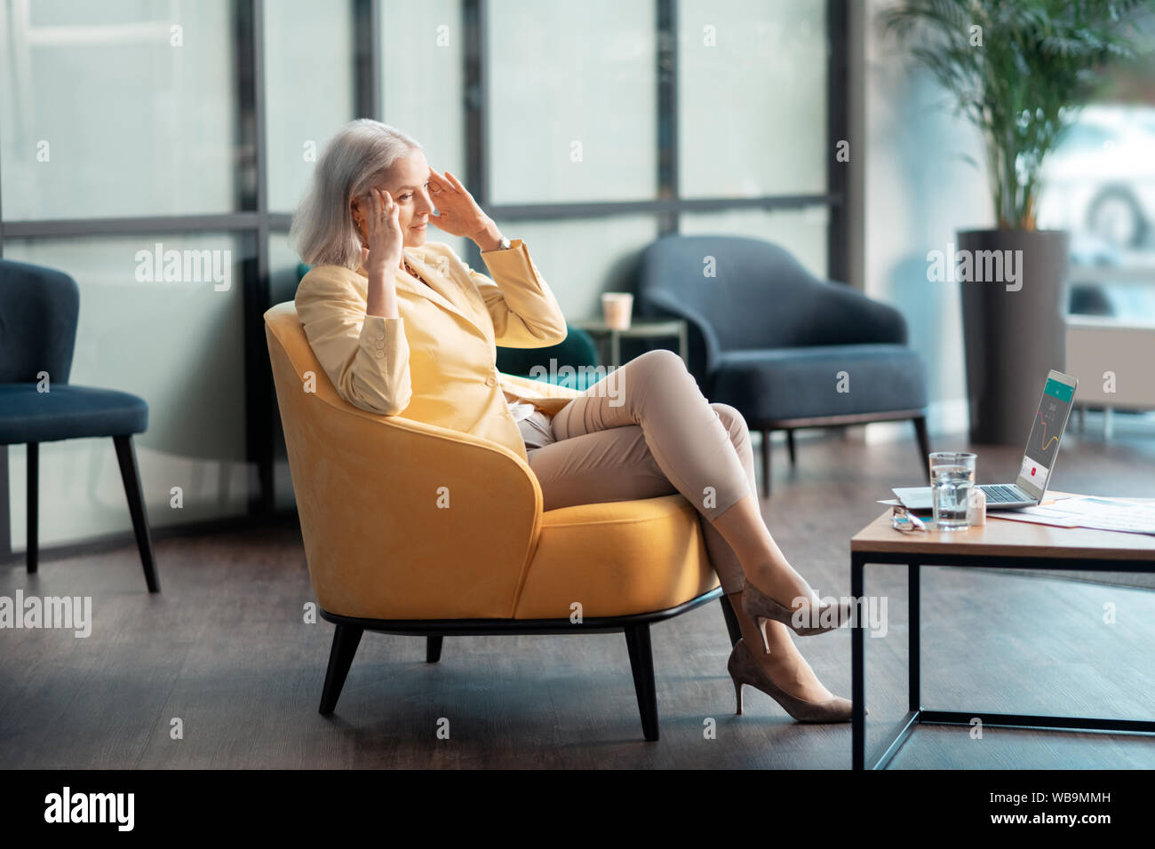 Senior Geschäftsfrau leiden unter Kopfschmerzen im Büro Stockfoto