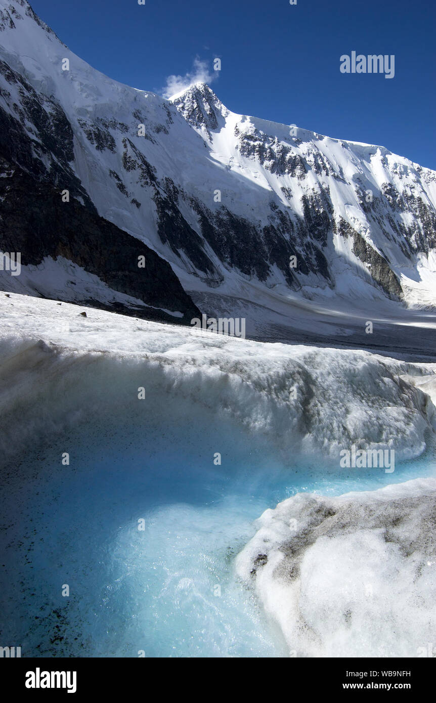 Schmelzwasser in Eis gegen Belukha Mountain Top, Altai Gebirge, Russland Stockfoto