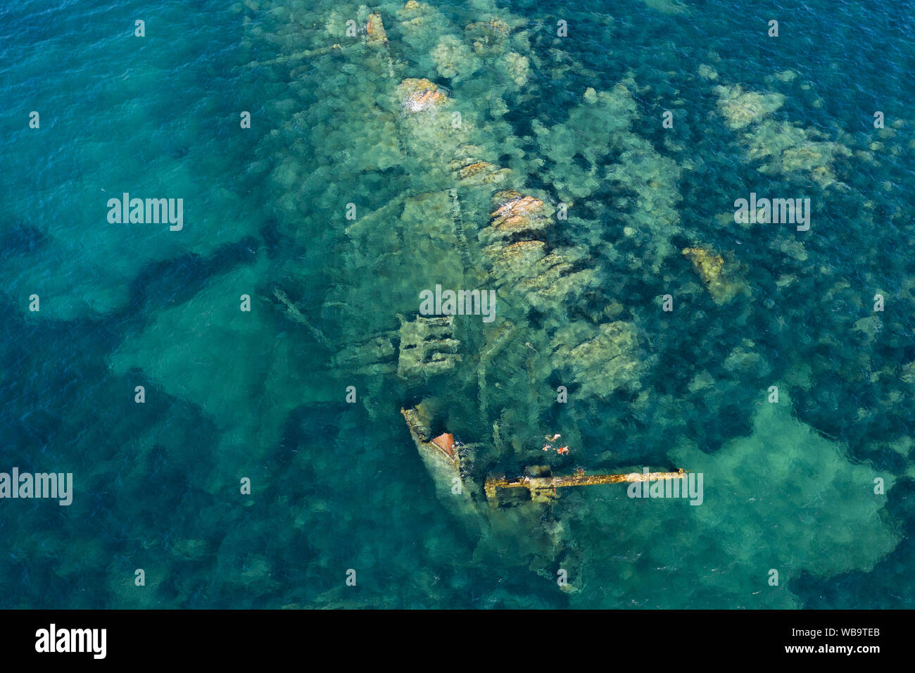 Ansicht von oben, beeindruckende Luftaufnahme eines Wracks im Meeresschutzgebiet von Tavolara. Einige Leute Schnorcheln in einem smaragdgrünen Meer. Stockfoto