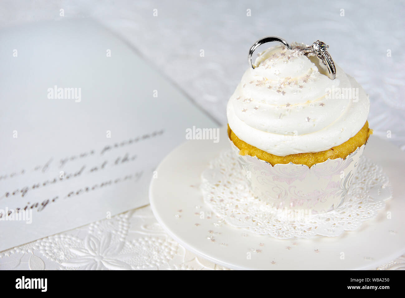 Diamantring und silberne Hochzeit Band in Cupcake Sahnehäubchen auf förmliche Einladung Stockfoto
