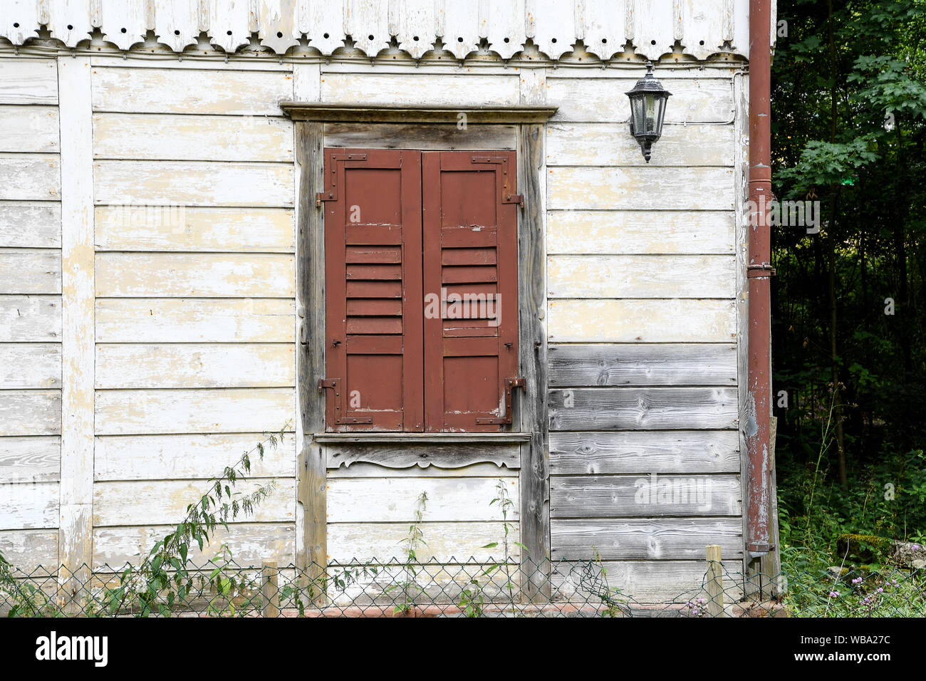 Altes Haus mit braunen geschlossenen Fensterläden aus Holz am Fenster Stockfoto