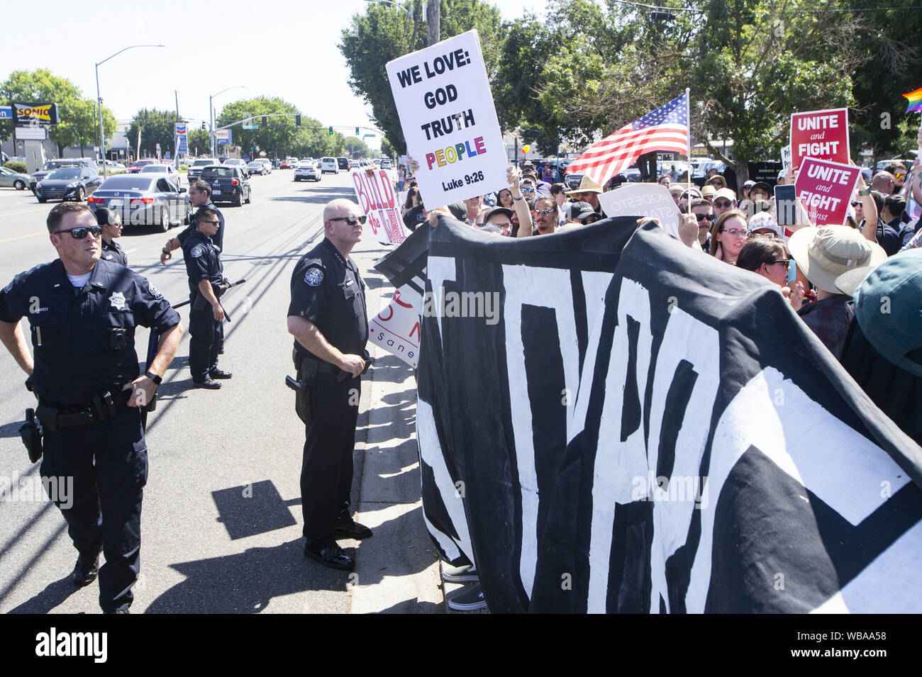 Modesto, CA, USA. 24 Aug, 2019. Modesto Polizei Chief Galen Carroll, Mitte, hat ein Auge auf die Demonstranten mit vielen seiner Beamten in eine Gerade Stolz Rallye Samstag, 12.08.24, 2019 in Modesto CA. Credit: Marty Bicek/ZUMA Draht/Alamy leben Nachrichten Stockfoto