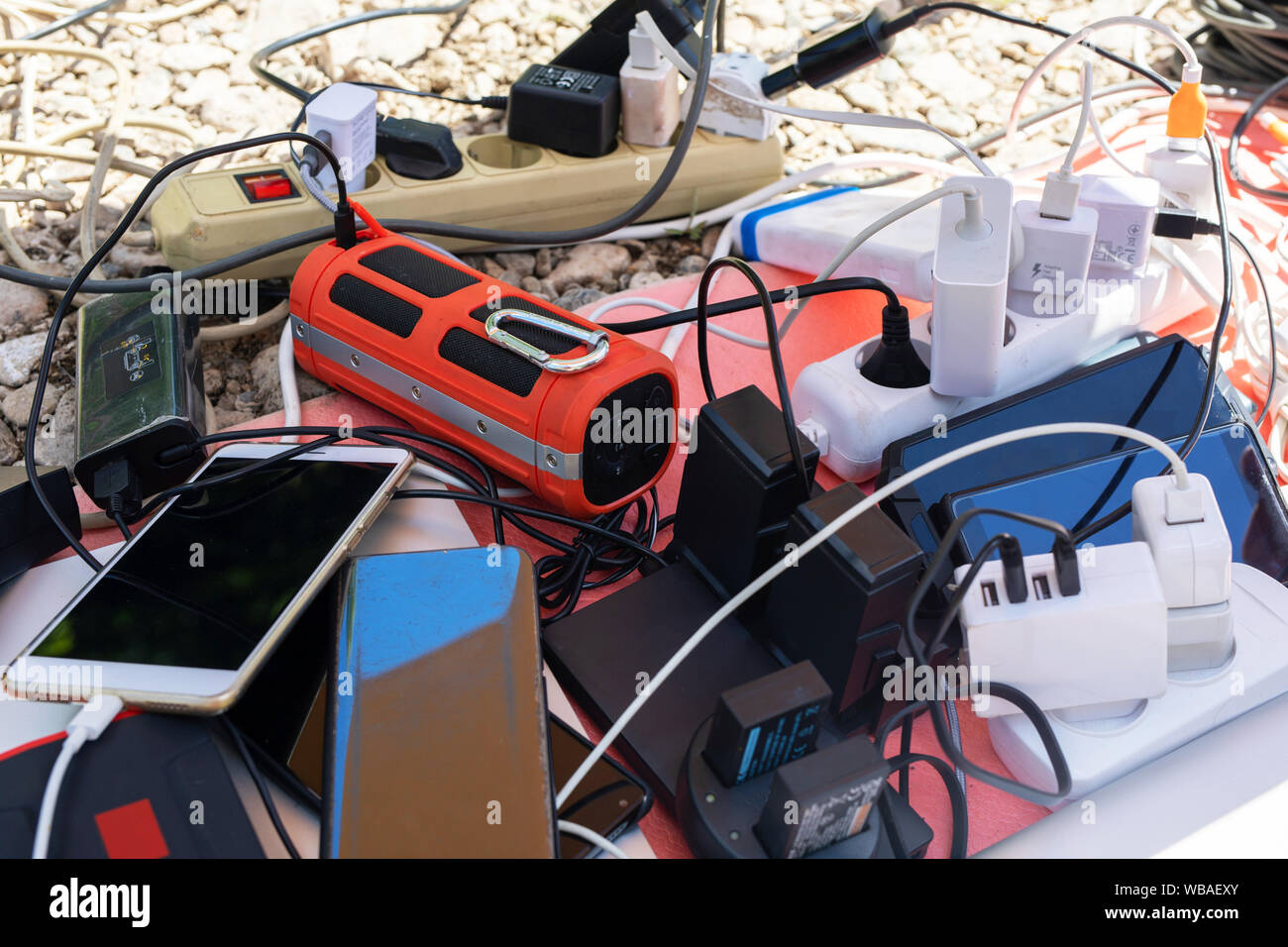 Viele elektrische Stecker an eine Steckdosenleiste oder Verlängerung verbunden. Ladegeräte in Gang Buchse gesteckt. Laden Gadgets, Smartphones und Electron Stockfoto