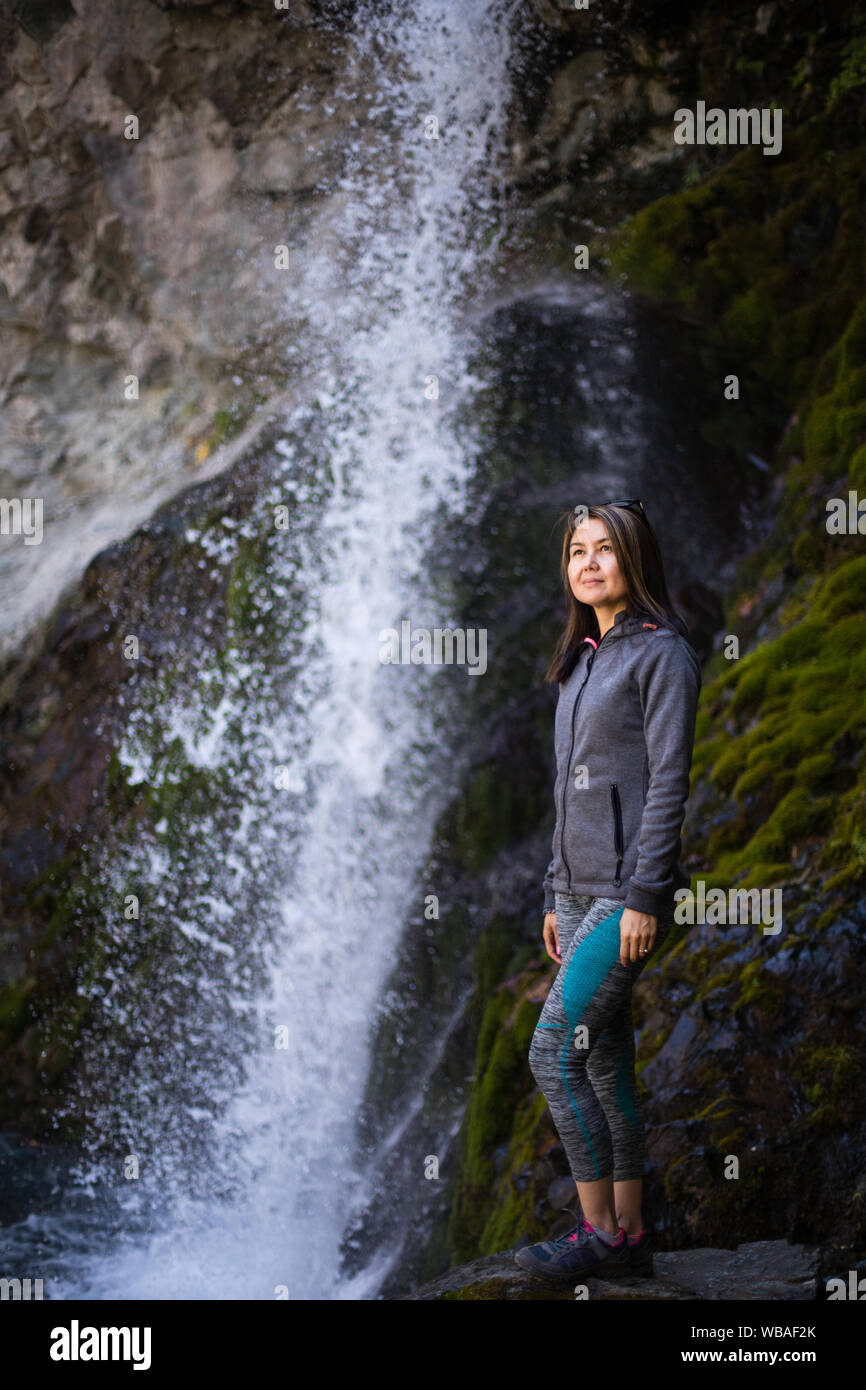 Posing neben einem beliebten Wasserfall im Alameddin-Tal in Kirgisistan Chuy Oblast. Stockfoto