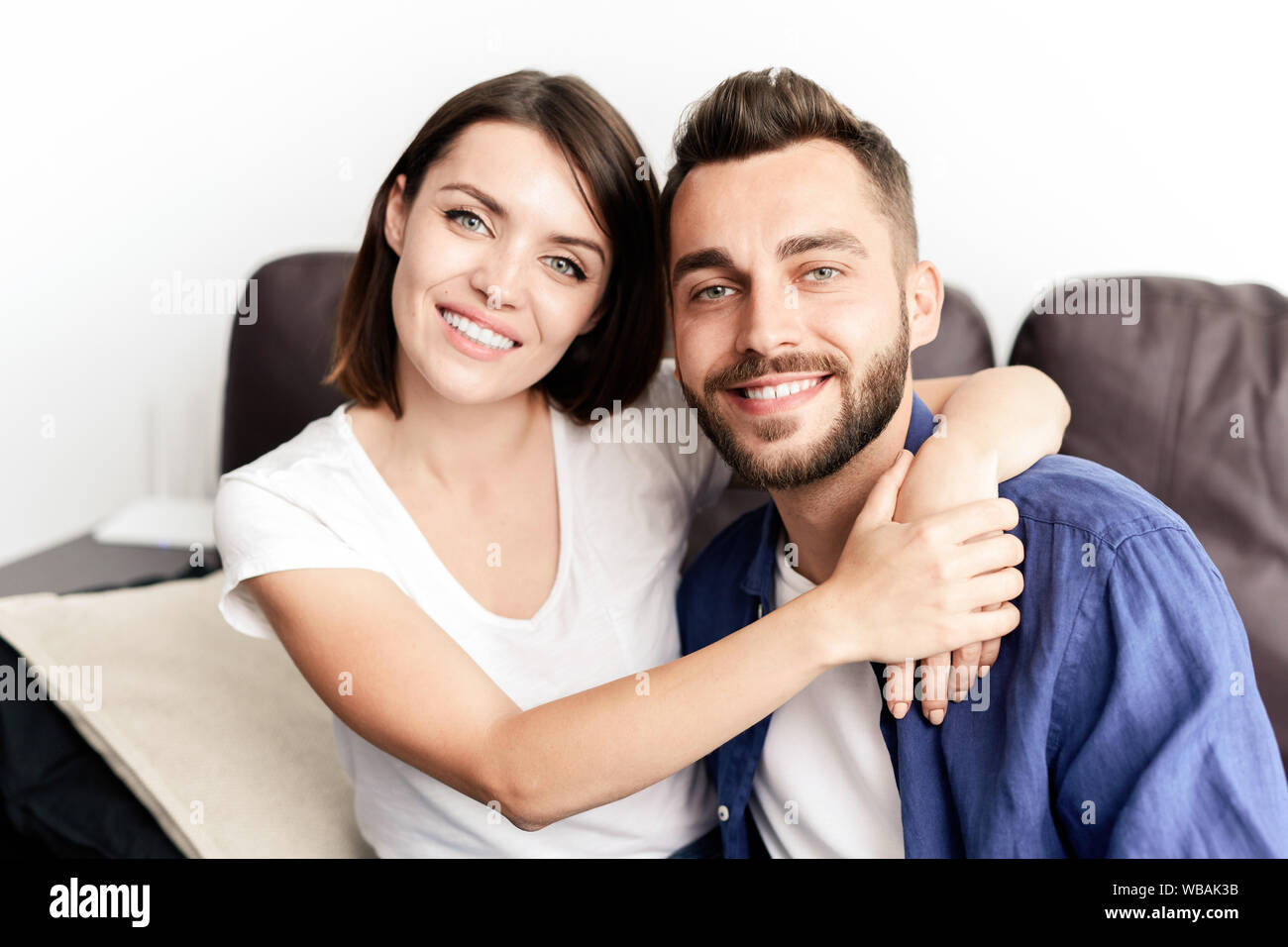 Portrait von fröhlicher junger schönes Paar sitzt auf einem Sofa Stockfoto