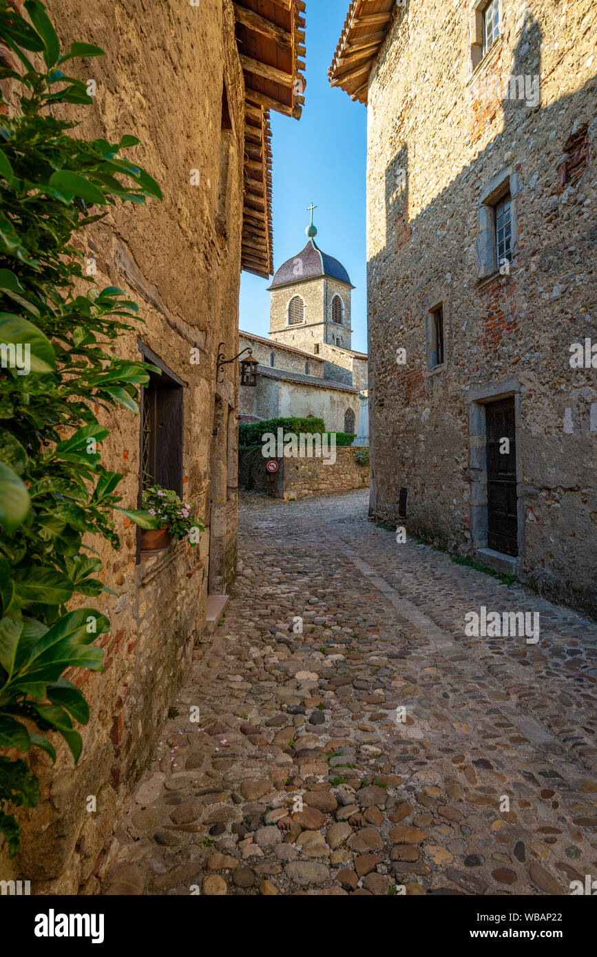 Schmale Straße mit einem Blick auf den Kirchturm, am Ende der Sommernachmittag, Perouges, Frankreich Stockfoto