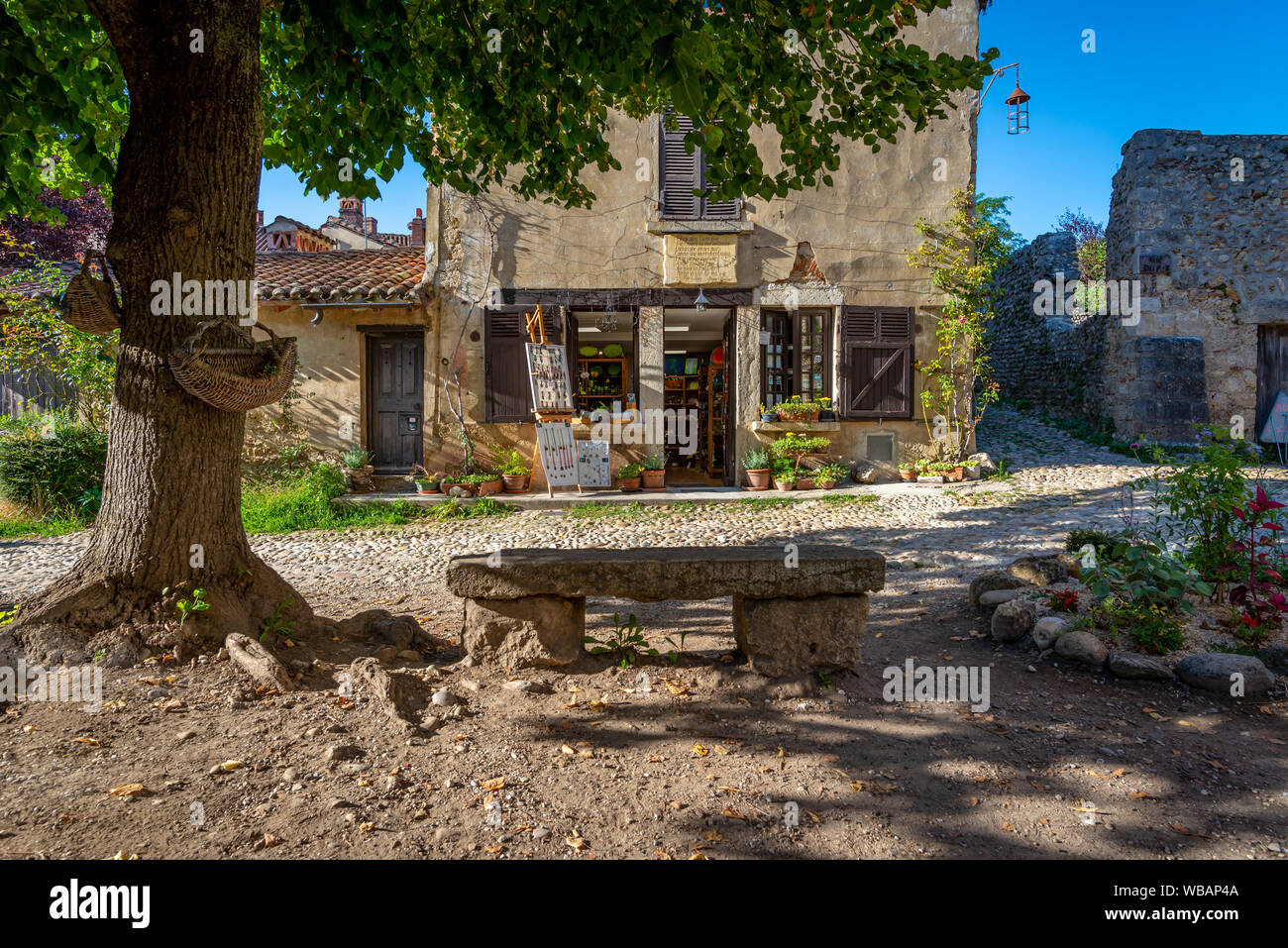 Altmodische store mit verwitterten Steinbank, am Ende eines Sommers Nachmittag werfen lange Schatten, Perouges, Frankreich genommen Stockfoto