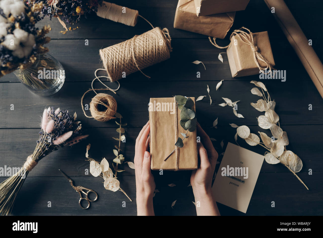 Direkt über der Ansicht von Frau verpacken Geschenke in Kraftpapier Stockfoto