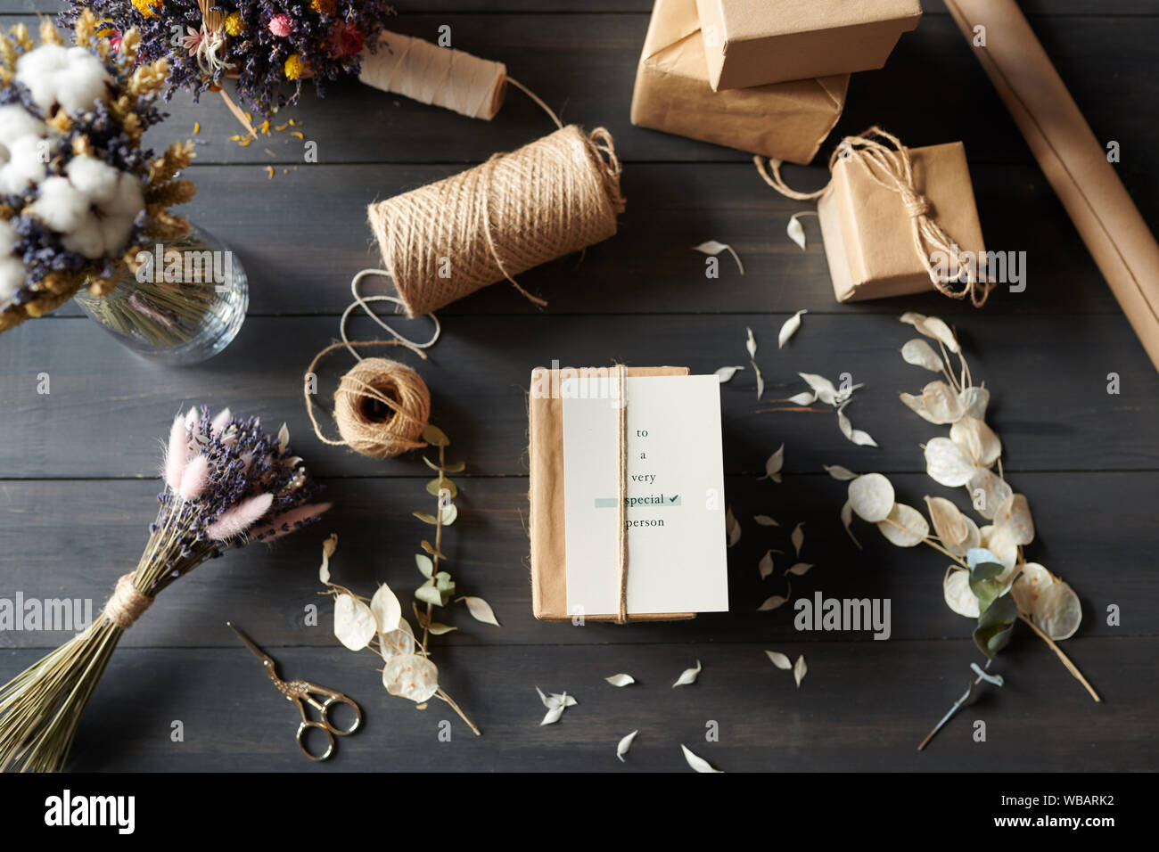 Oben Ansicht von verpackten Geschenke auf Tabelle mit unordentlichen Blütenblätter Stockfoto