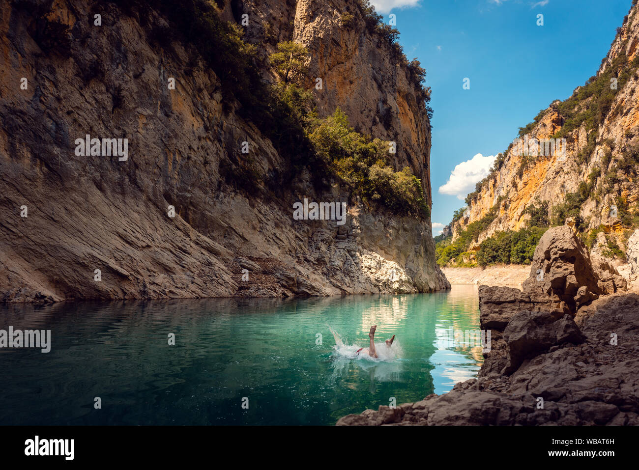Mann in das Wasser von einer Schlucht in den Bergen der Pyrenäen springen Stockfoto