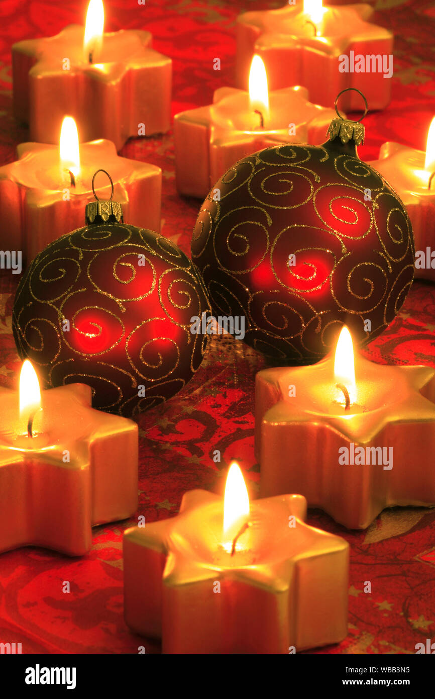 Rote Christbaumkugeln und Brennen von kleinen, sternförmigen Kerzen. Studio  Bild. Schweiz Stockfotografie - Alamy