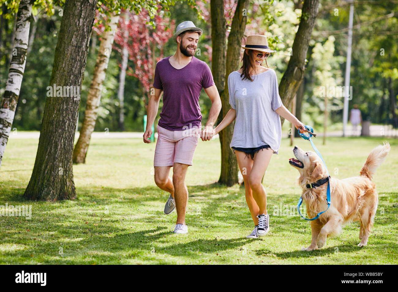 Junges Paar gehen gemeinsam mit ihrem Hund in den Park im Sommer Stockfoto