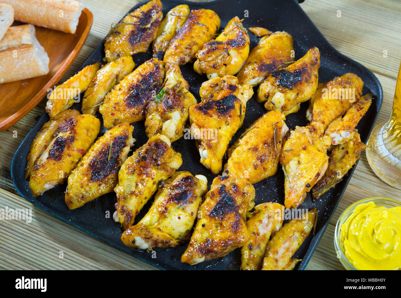 Gebackene Chicken Wings mit scharfer Sauce serviert auf Pfanne Stockfoto