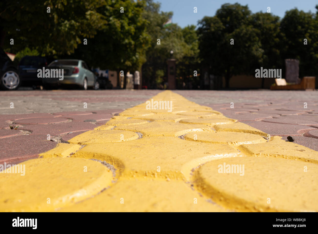 Gelbe Division Streifen auf den Pflastersteinen, die bis in die Ferne. Lineare Perspektive Stockfoto